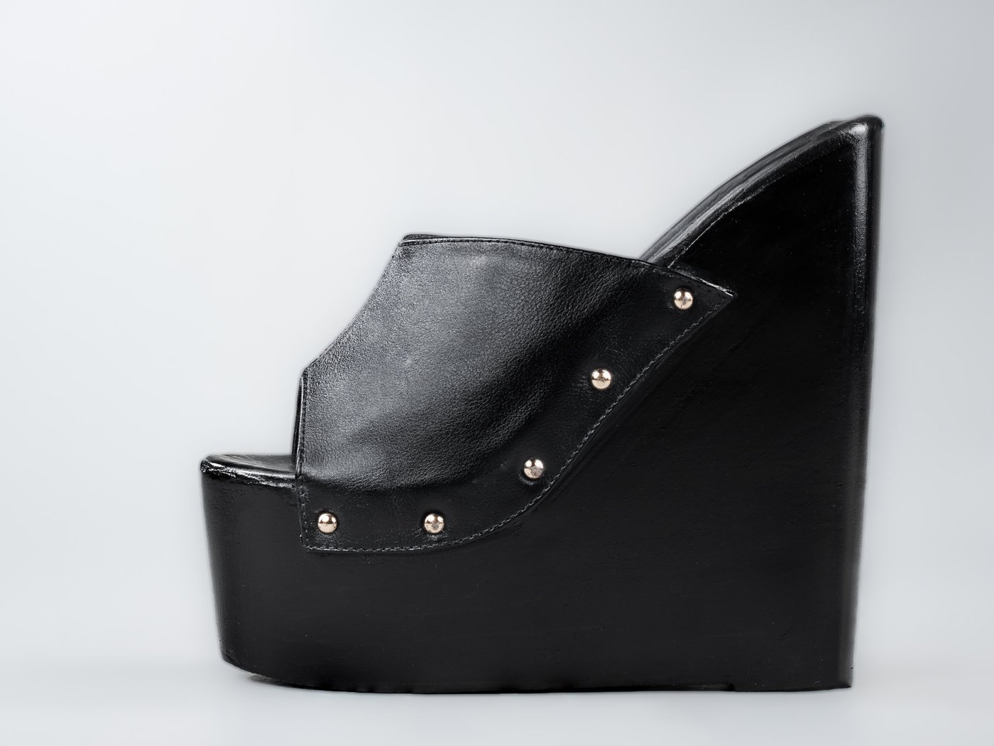 The Amber, side profile, an open-toe platform wedge mule in black full-grain leather